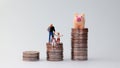Pile of coins and miniature people. Royalty Free Stock Photo